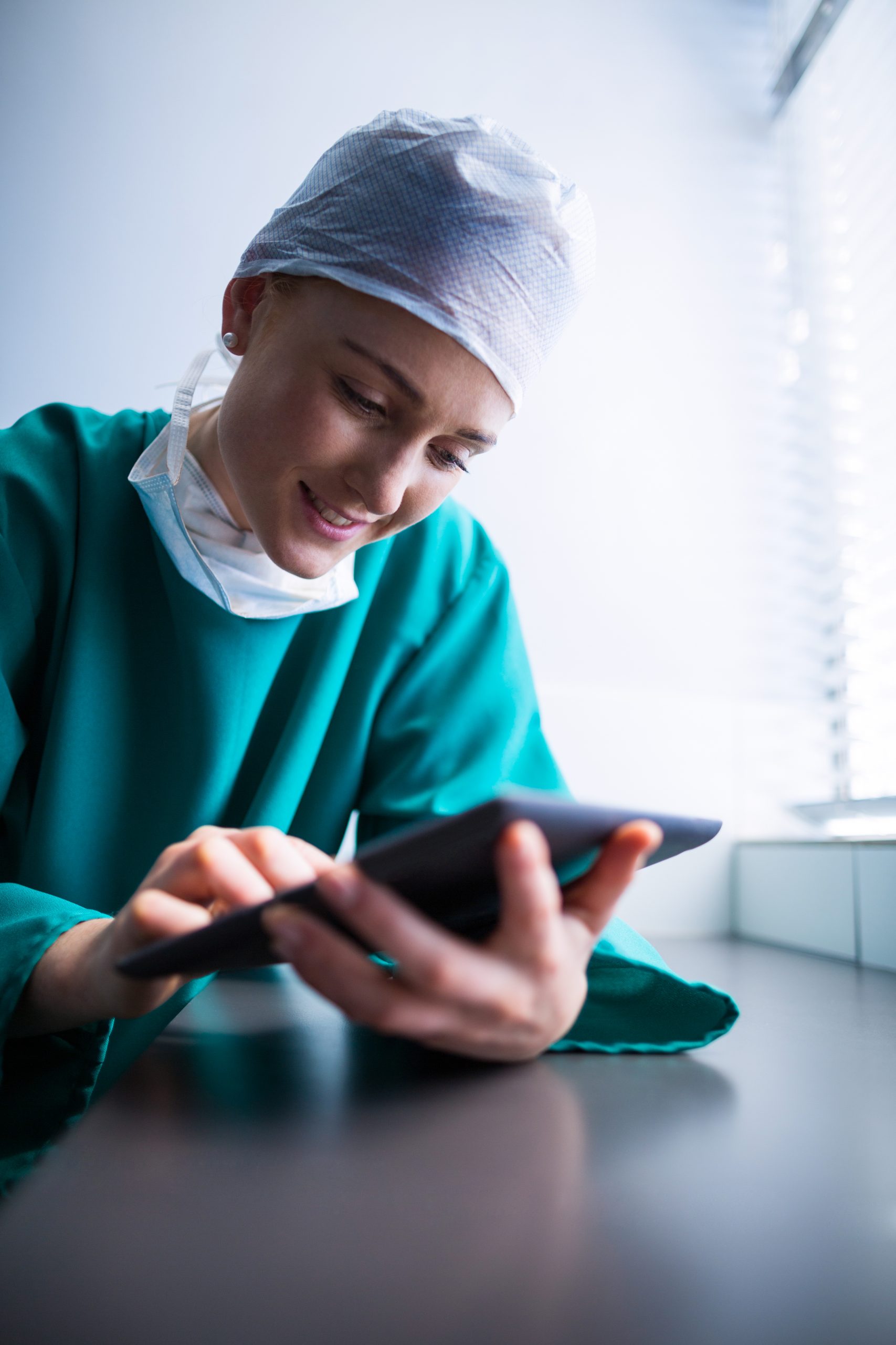 Female surgeon using digital tablet of hospital